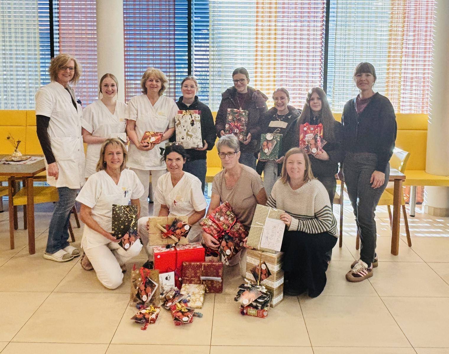 Geschenk&uuml;bergabe bei der Wohn- und Pflegeheim Lienz &ndash; von links nach rechts: stehend Daniela Meier (Pflegedienstleitung WPH Lienz) mit leitenden Pflegekr&auml;fte des WPH-Lienz, Leonie, Hanna, Sophia und Isabelle ((Sch&uuml;lerinnen der FS. f. wirtsch. Berufe d. Dominikanerinnen), Petra Egger (Dekanatsjugend Lienz). Hockend von links nach rechts: leitende Pflegekr&auml;fte des WPH-Lienz, Simone Ortner-Trebo (Freiwilligenzentrum Osttirol). Foto: Regionsmanagement Osttirol/FWZ