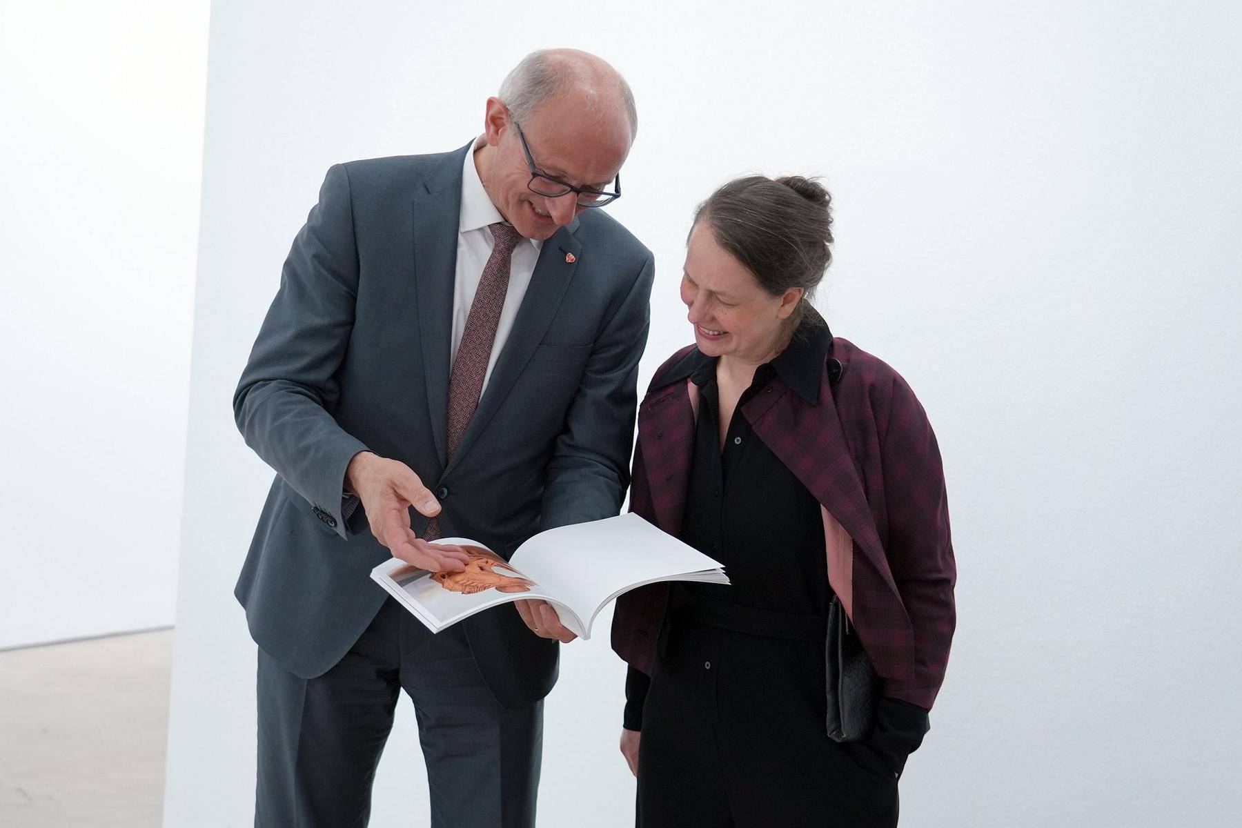 LH Anton Mattle und die K&uuml;nstlerin Rosmarie Lukasser schauen sich gemeinsam das Buch an. (c) Land Tirol/Sidon